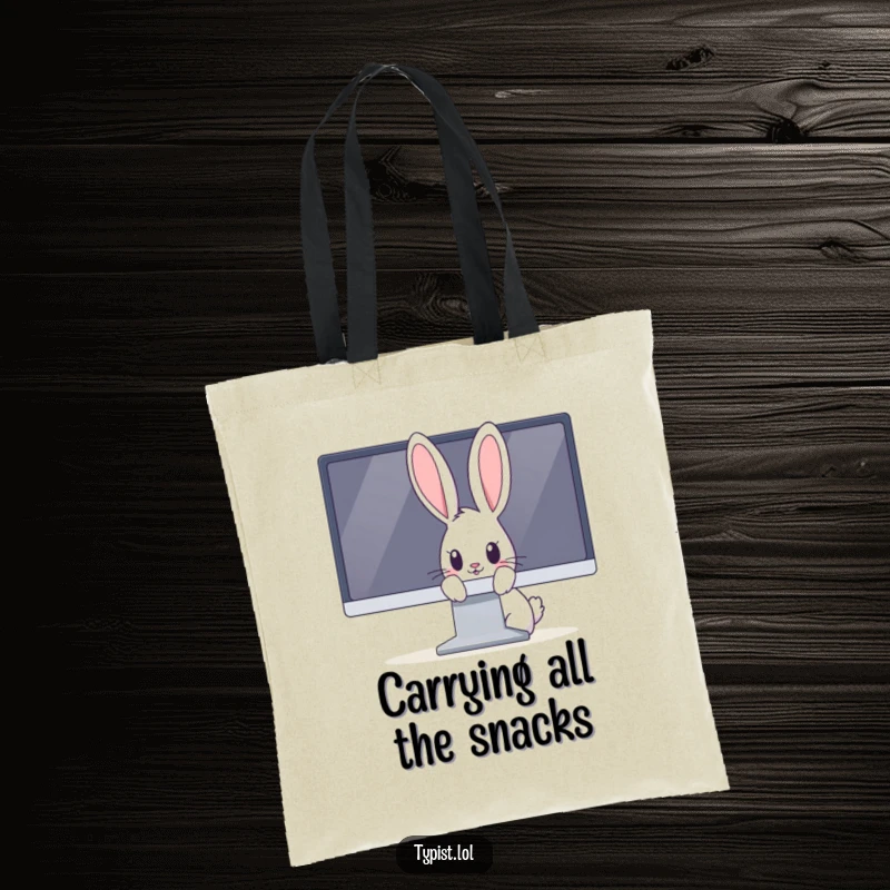 Funny rabbit tote bag showing a curious bunny peeking over the edge of a large computer monitor, looking playful.